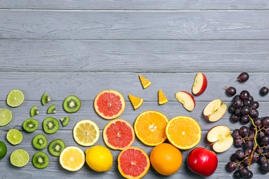 Rainbow composition with fresh fruits on wooden background, flat lay