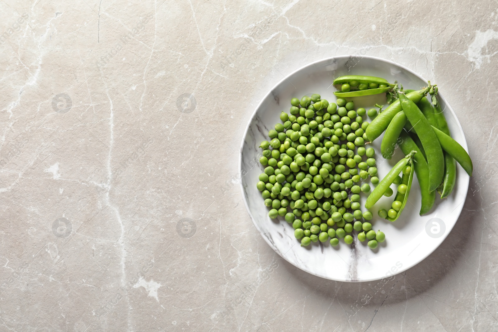 Photo of Plate with green peas on light background, top view