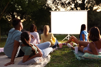 Young people watching movie in open air cinema. Space for text