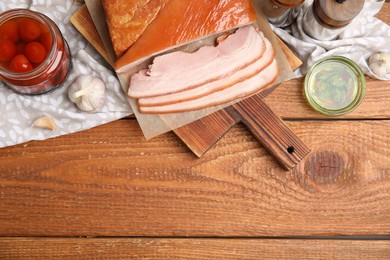 Photo of Flat lay composition with delicious smoked bacon on wooden table, space for text