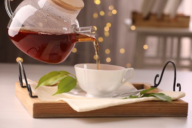 Photo of Pouring tea into cup at light table, closeup