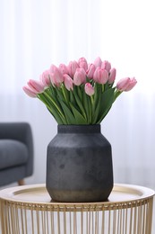 Photo of Bouquet of beautiful pink tulips in vase on table indoors