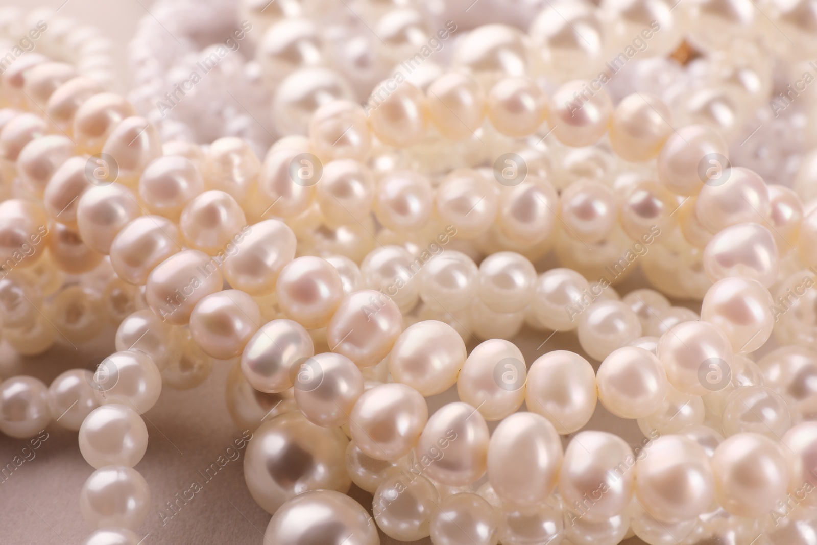 Photo of Elegant pearl necklaces as background, closeup view