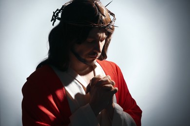 Photo of Jesus Christ with crown of thorns praying on white background