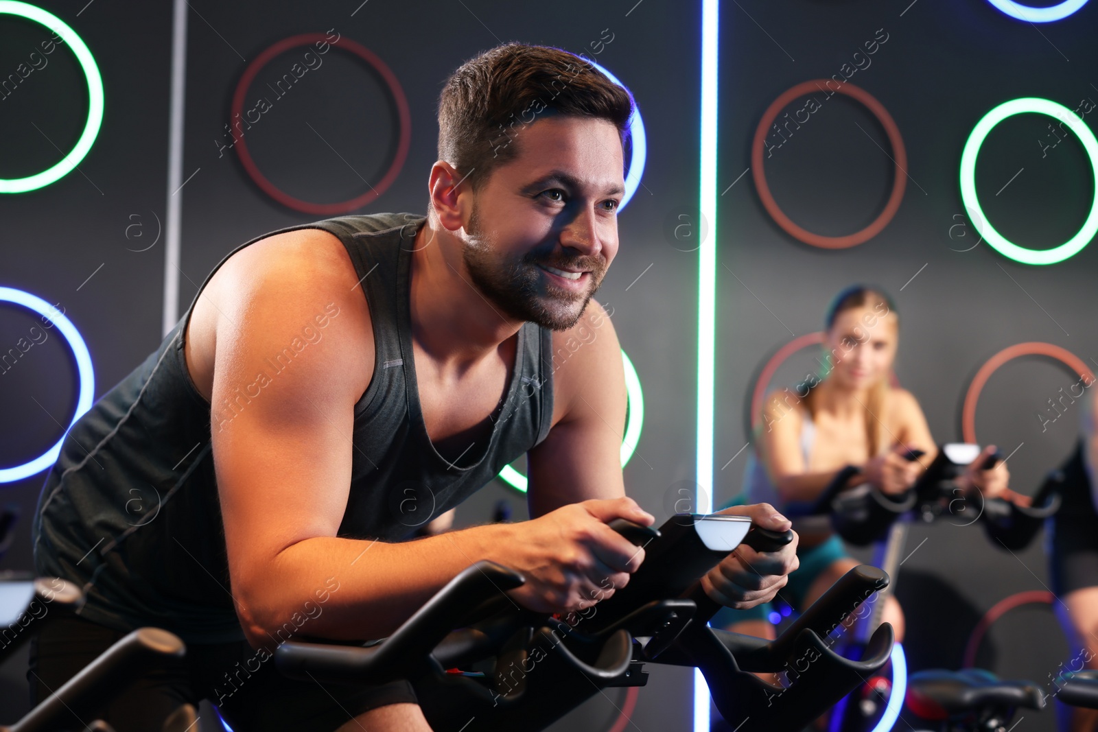 Photo of Man and woman training on exercise bikes in fitness club
