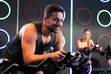 Man and woman training on exercise bikes in fitness club
