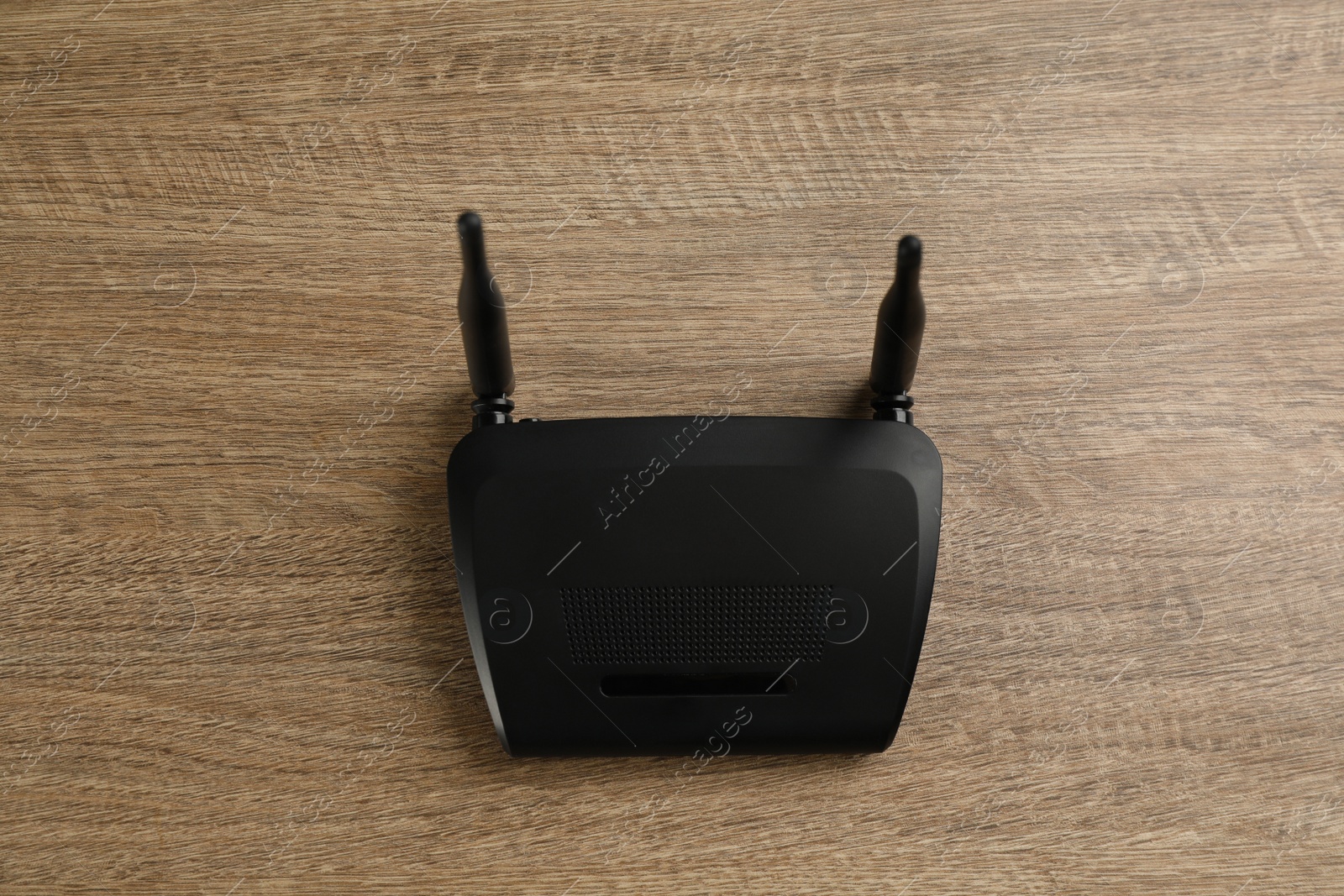 Photo of Modern Wi-Fi router on wooden background, top view