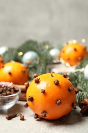 Photo of Delicious fresh tangerines with cloves on light table. Christmas celebration