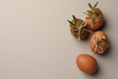 Photo of Festively decorated chicken eggs on light grey background, flat lay with space for text. Happy Easter