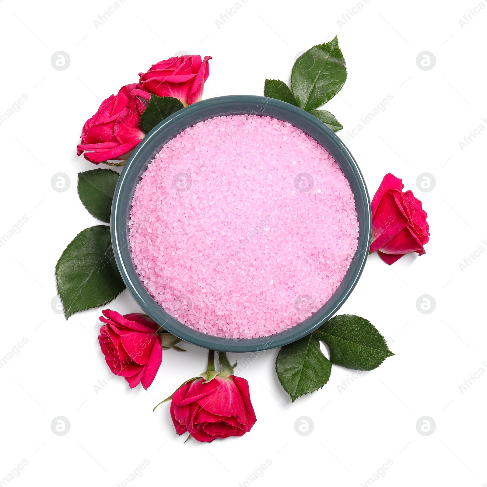 Photo of Pink sea salt in bowl, roses and green leaves isolated on white, top view