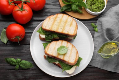 Delicious Caprese sandwiches with mozzarella, tomatoes and basil on wooden table, flat lay