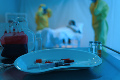 Medical bowl with samples of virus on table in quarantine ward