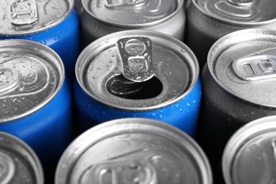 Energy drinks in wet cans as background, closeup. Functional beverage