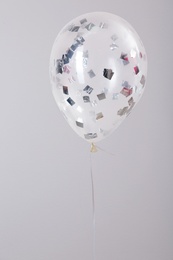 Photo of Bright balloon with sparkles on grey background