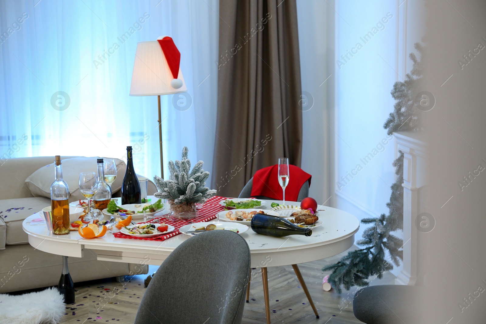 Photo of Dirty dishes on white table in room. Mess after new year party