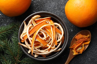 Dry peels, oranges and fir branch on gray textured table, flat lay