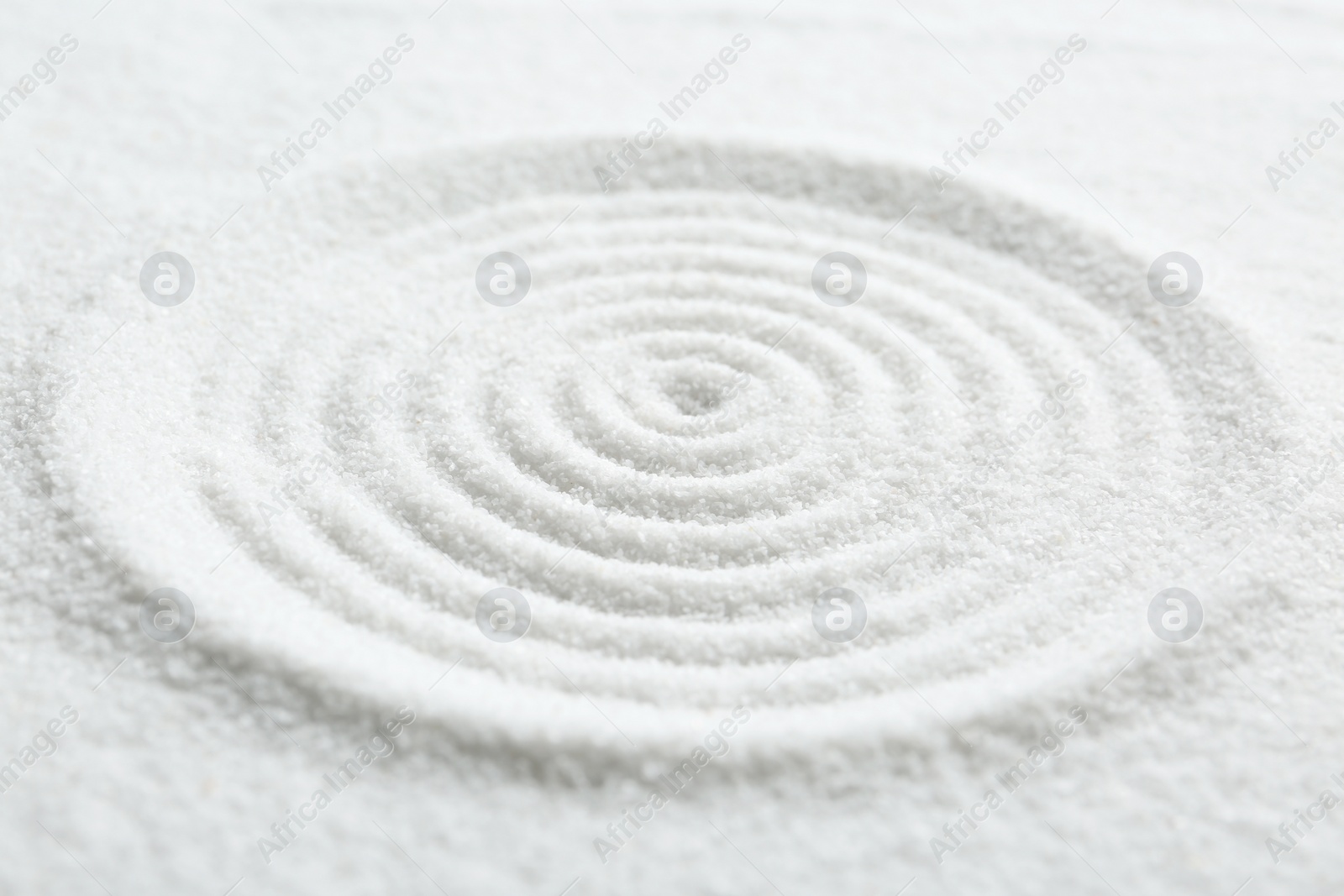 Photo of Zen rock garden. Circle pattern on white sand, closeup