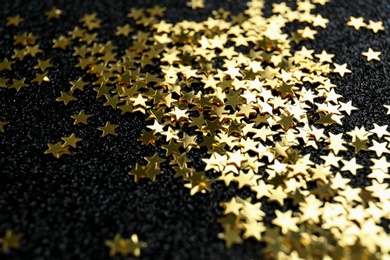 Photo of Confetti stars on black background, closeup. Christmas celebration