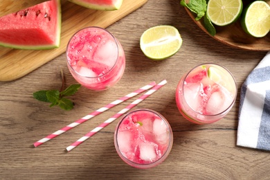 Photo of Delicious refreshing watermelon drink on wooden table, flat lay