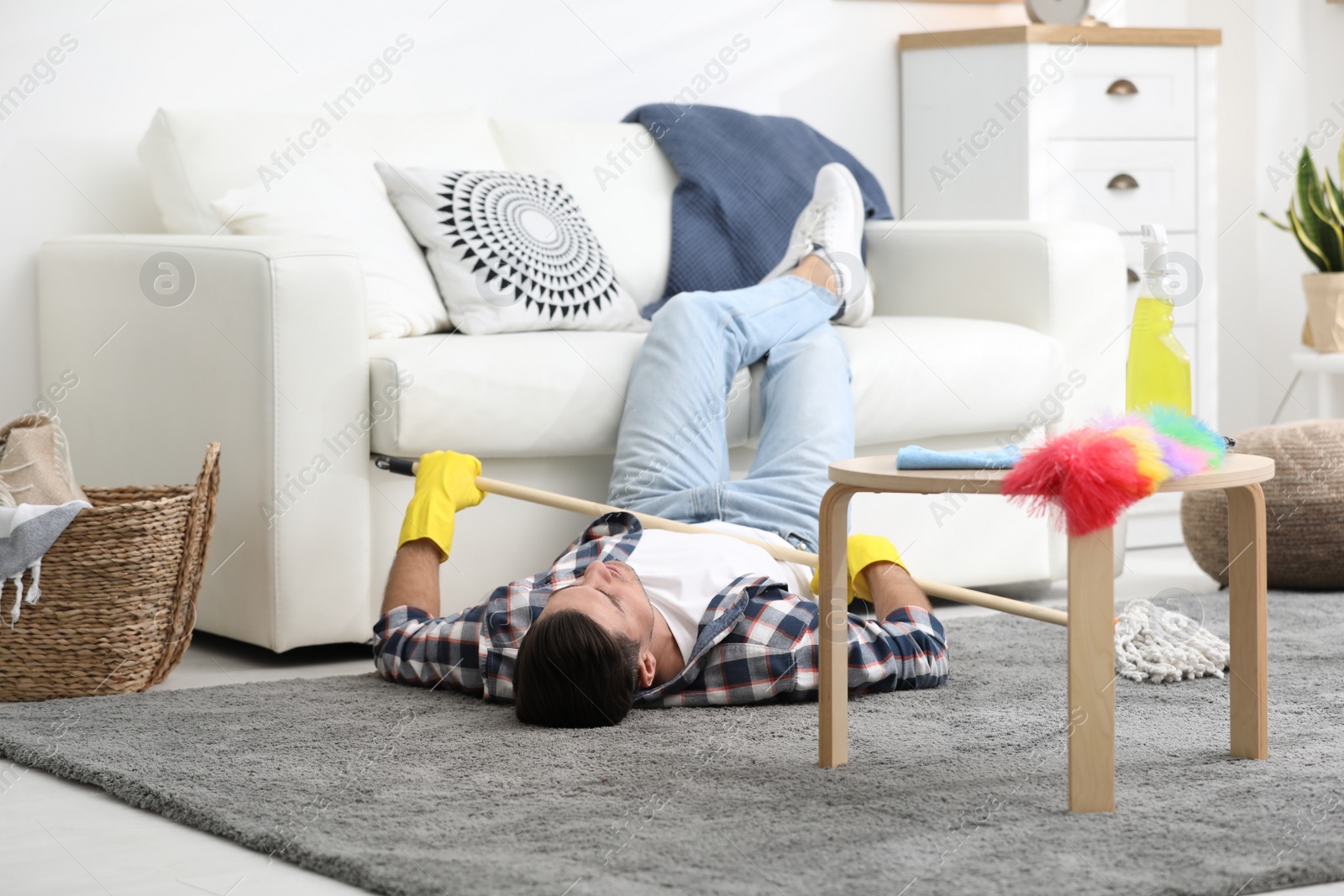 Photo of Lazy man procrastinating while cleaning at home