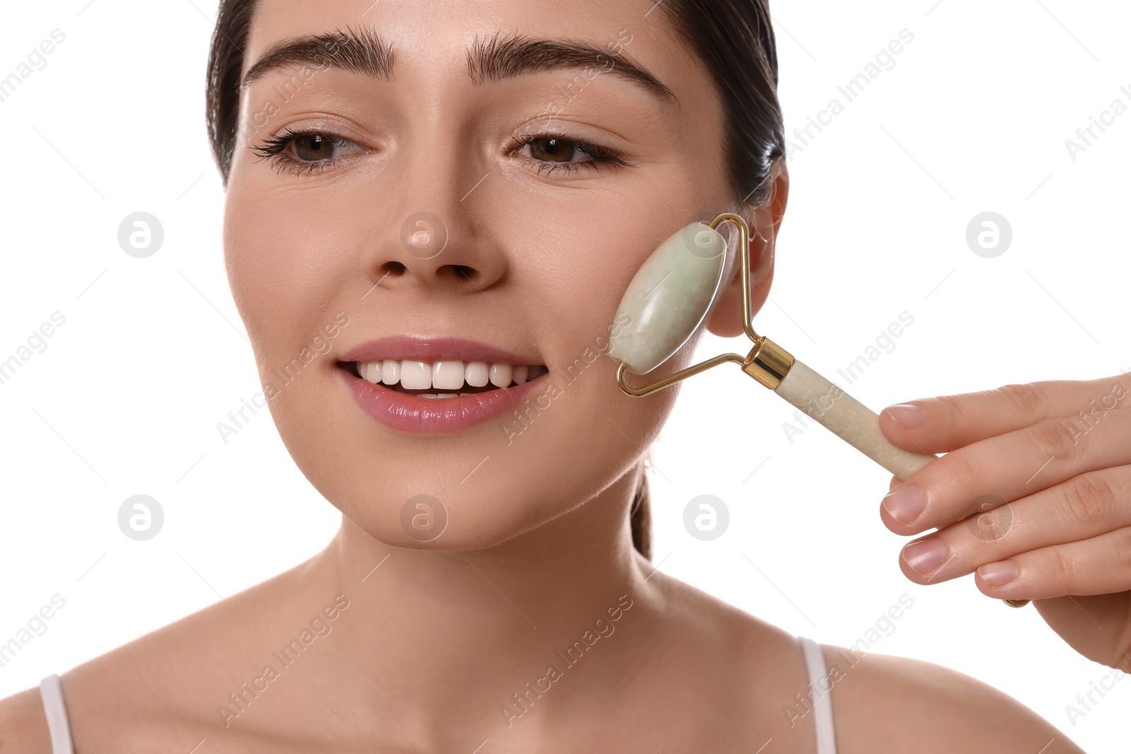 Photo of Young woman massaging her face with jade roller on white background