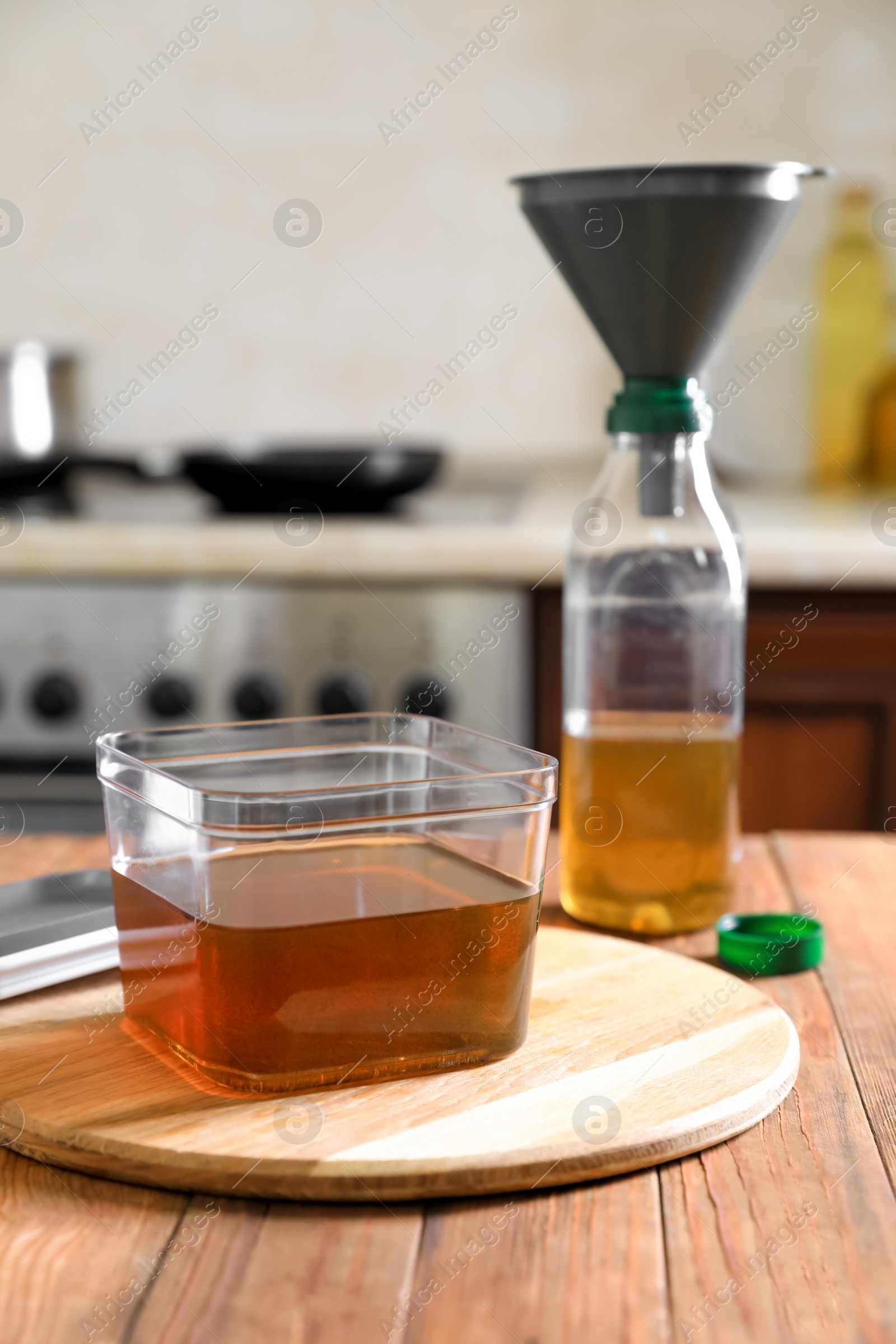 Photo of Used cooking oil on wooden table in kitchen