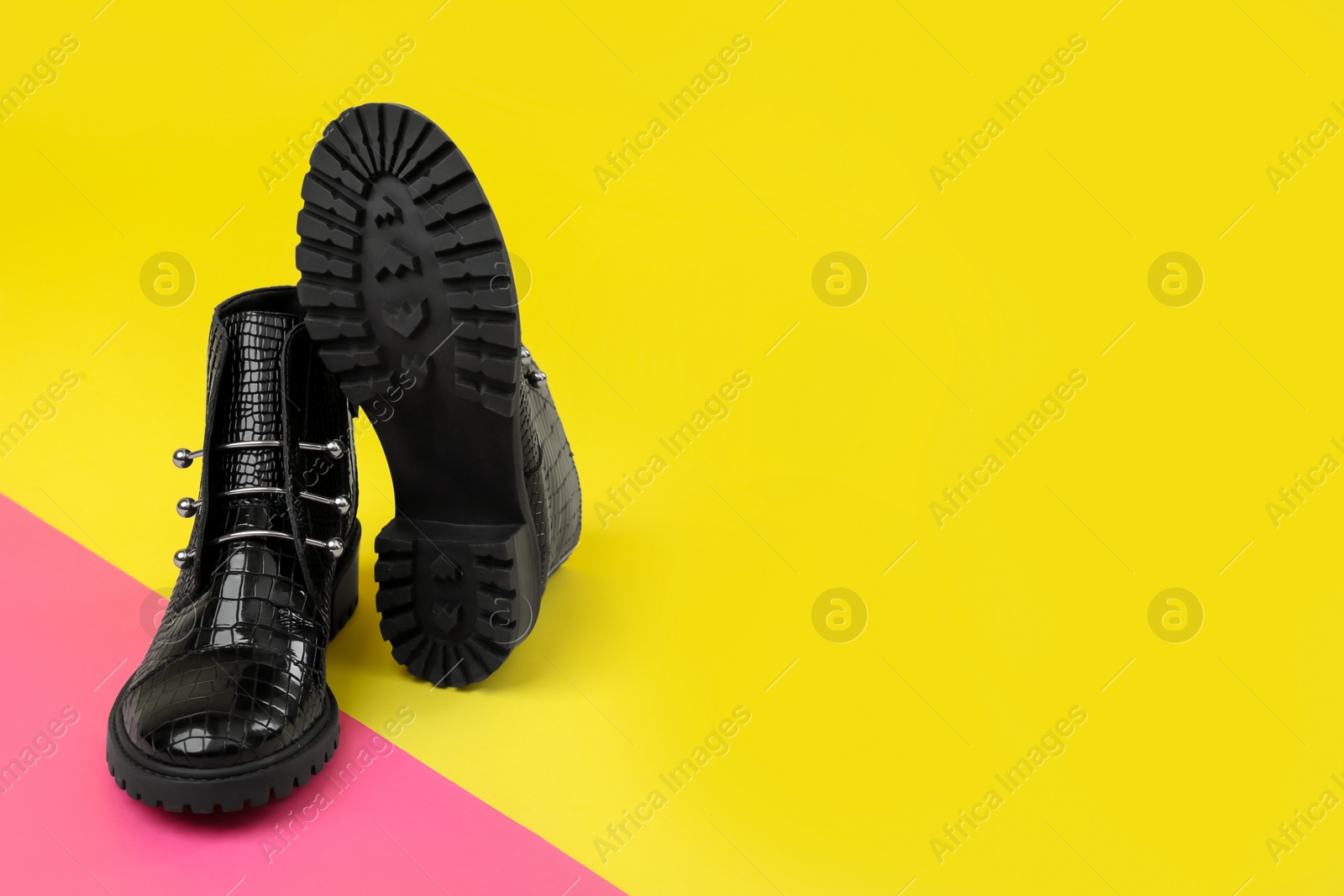 Photo of Pair of stylish ankle boots on color background. Space for text