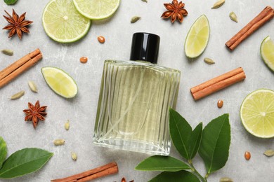 Photo of Flat lay composition with bottleperfume, lime and spices on light grey background