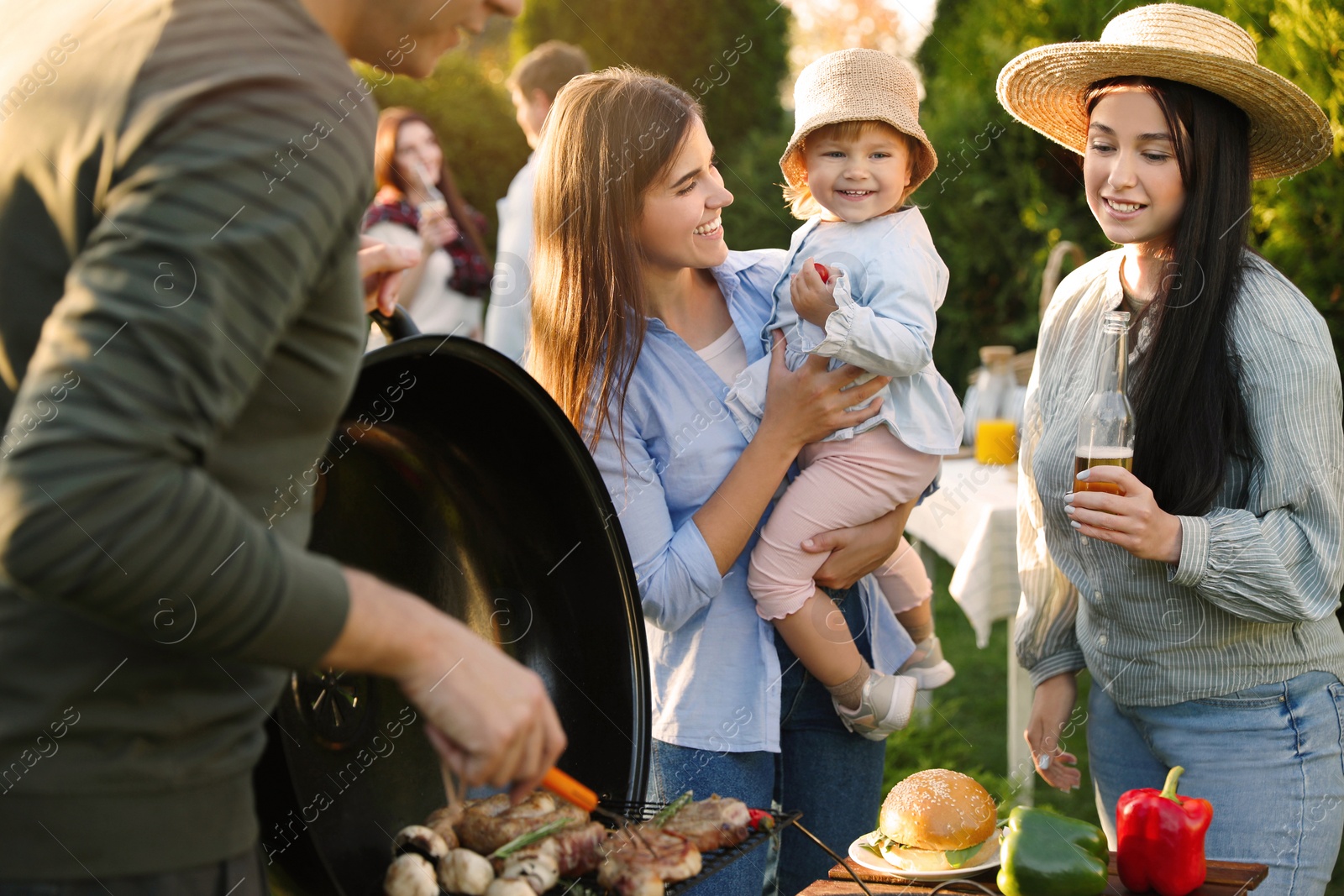 Photo of Family with friends having barbecue party outdoors