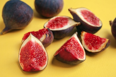 Photo of Delicious ripe figs on yellow background, closeup