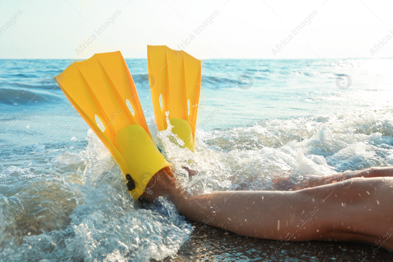 Photo of Woman in flippers near sea on beach, closeup