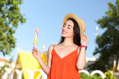 Photo of Happy young woman with delicious ice cream outdoors