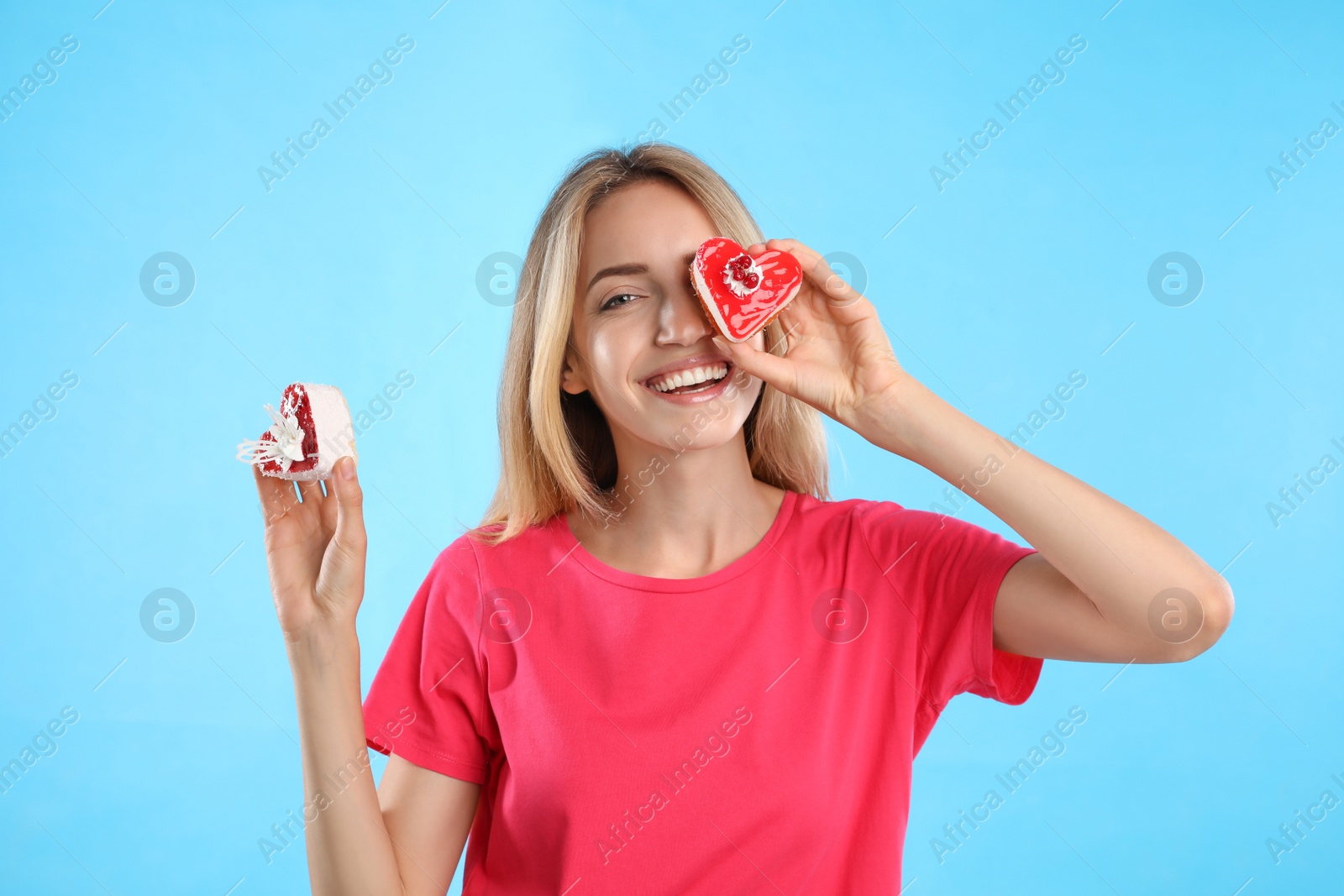Photo of Concept of choice between healthy and junk food. Woman with cakes on light blue background