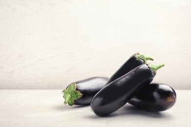 Photo of Ripe eggplants on table against light background