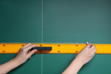 Woman drawing with chalk and ruler on green board, closeup. Space for text