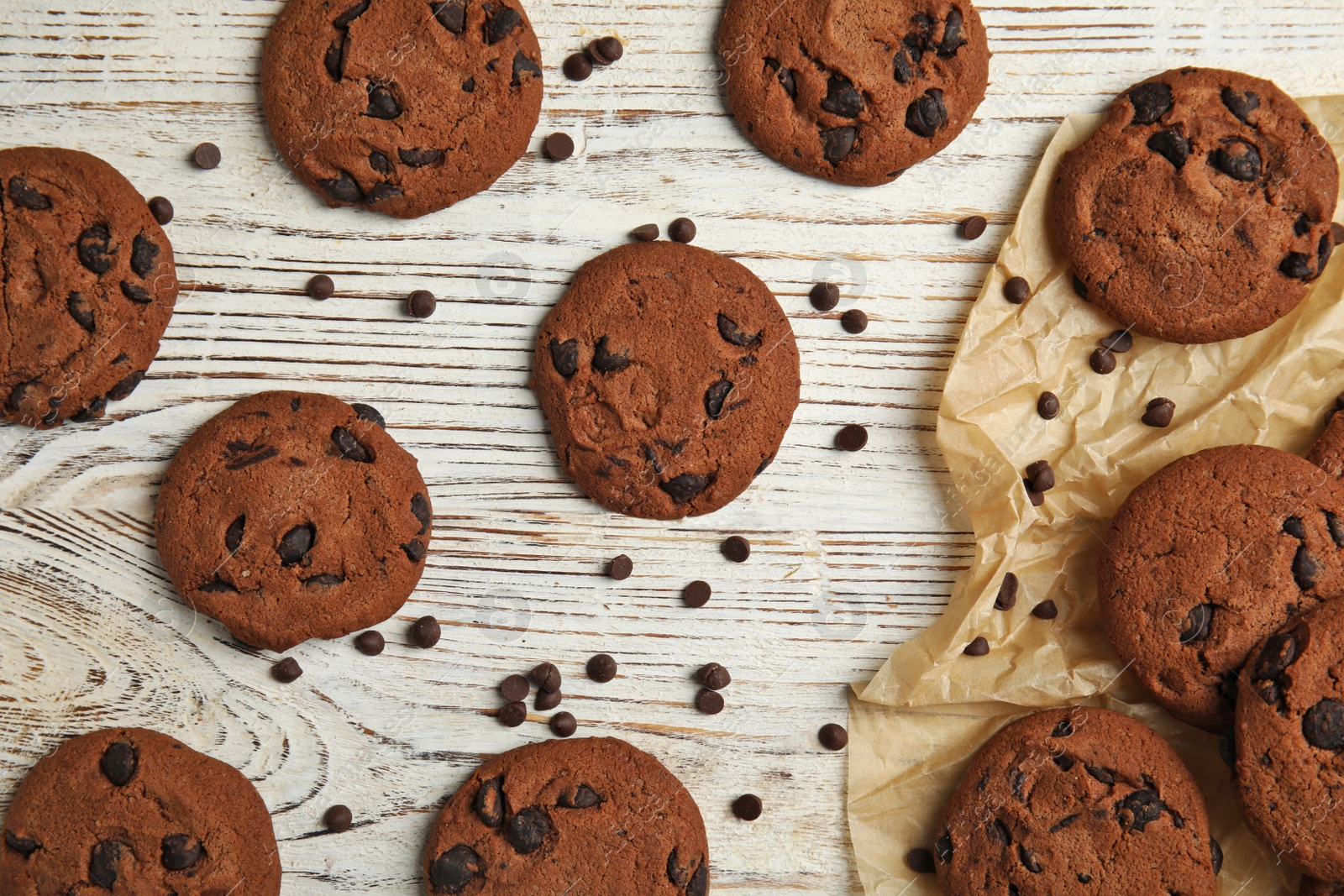 Photo of Delicious chocolate chip cookies on wooden table, flat lay