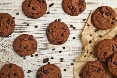 Delicious chocolate chip cookies on wooden table, flat lay