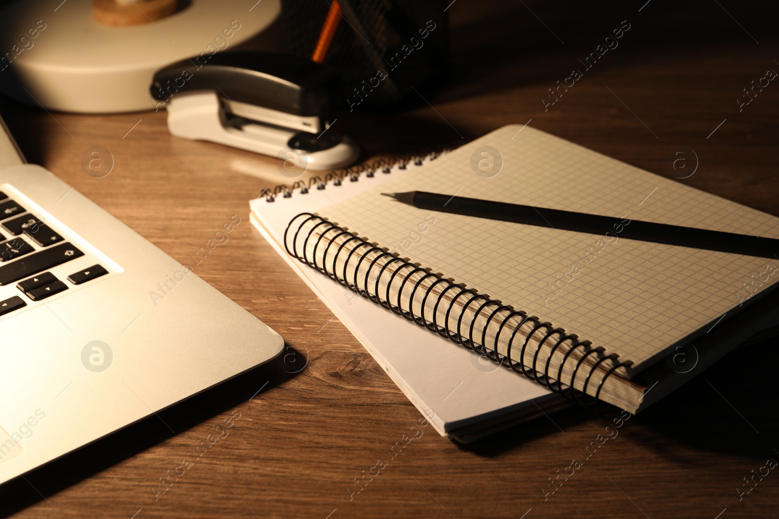 Photo of Notebooks and pencil on wooden table, closeup