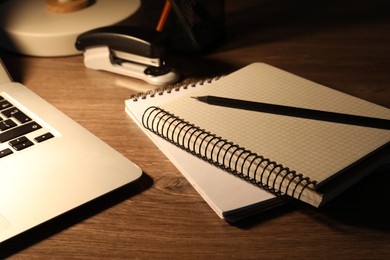 Notebooks and pencil on wooden table, closeup