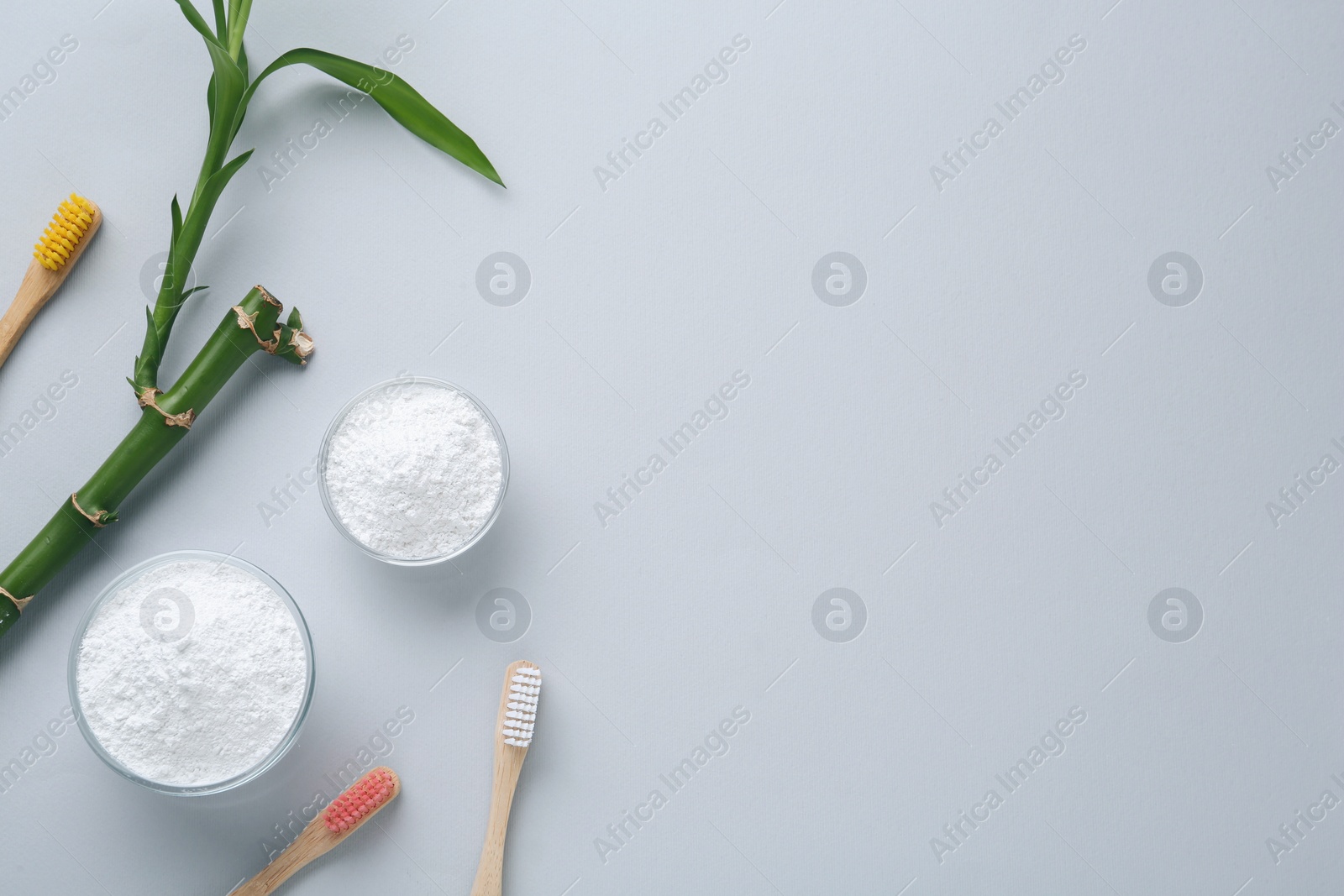 Photo of Tooth powder, brushes and bamboo stem on white background, flat lay. Space for text