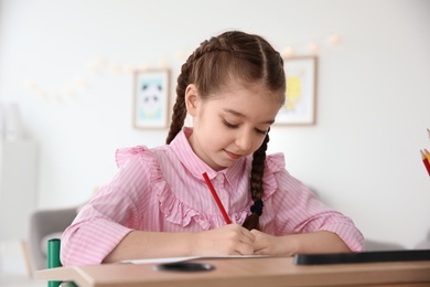 Photo of Little girl with autistic disorder drawing at home