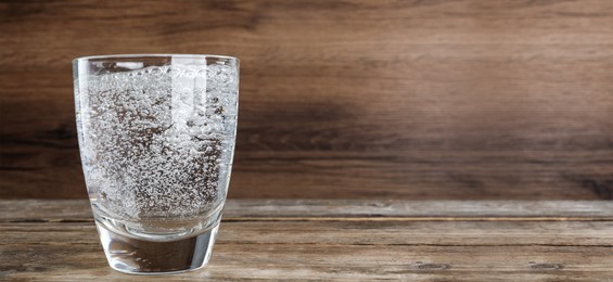 Image of Refreshing soda water in glass on wooden table. Banner design with space for text