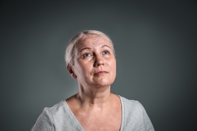 Photo of Mature woman suffering from depression on grey background