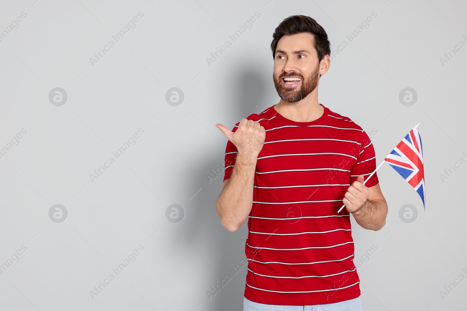 Photo of Man with flag of United Kingdom on light grey background, space for text