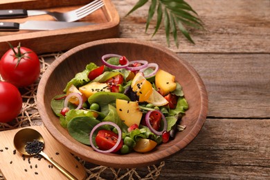 Delicious salad with peach, green peas and vegetables served on wooden table