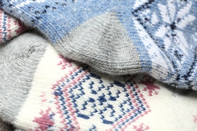 Photo of Different knitted woolen socks as background, closeup