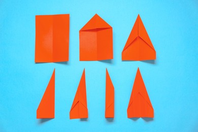 Photo of Making paper plane step by step. Instruction on light blue background, flat lay