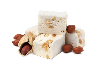 Pieces of delicious nougat and nuts on white background