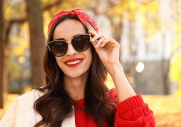 Photo of Beautiful woman wearing sunglasses in park. Autumn walk