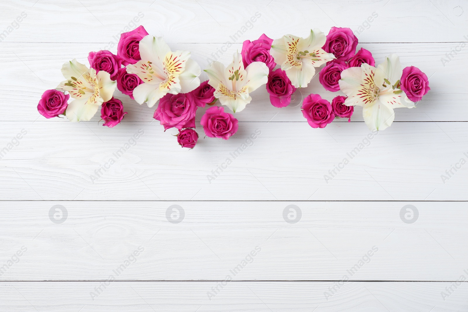 Photo of Fresh flowers on wooden background, top view with space for text